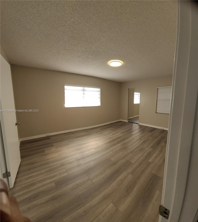 unfurnished room featuring wood-type flooring and a textured ceiling