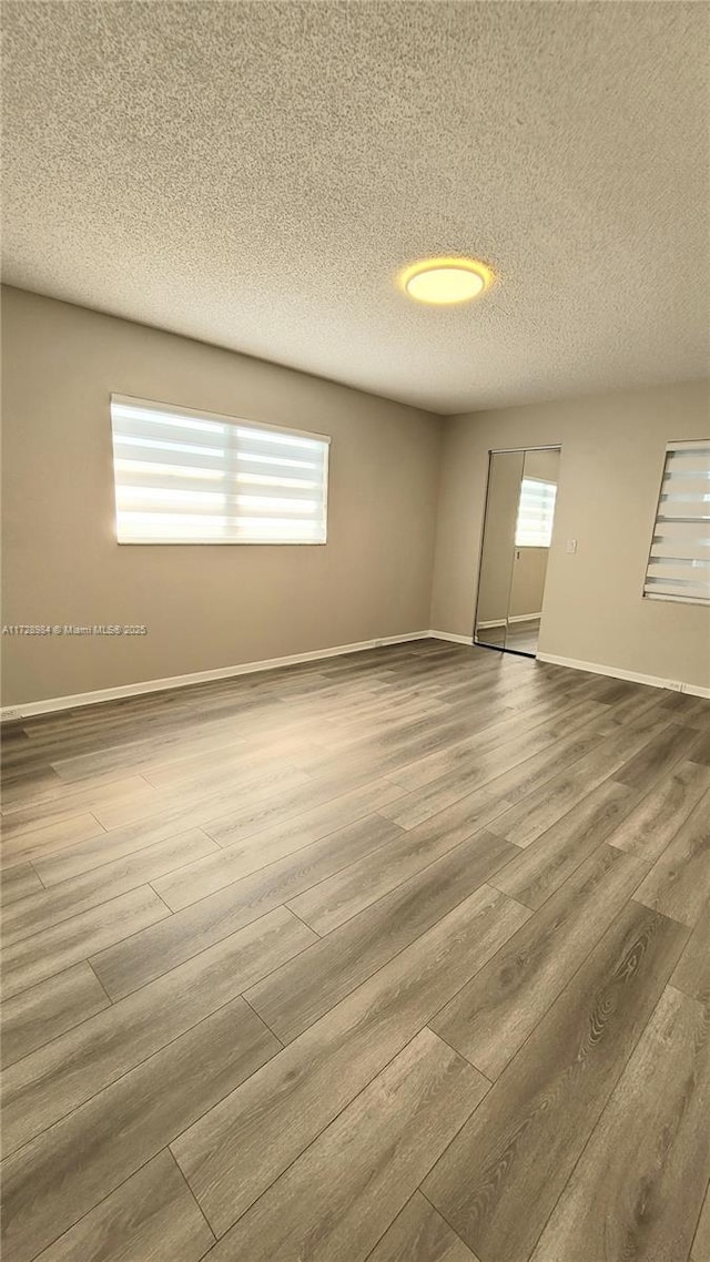 empty room with a textured ceiling and hardwood / wood-style floors