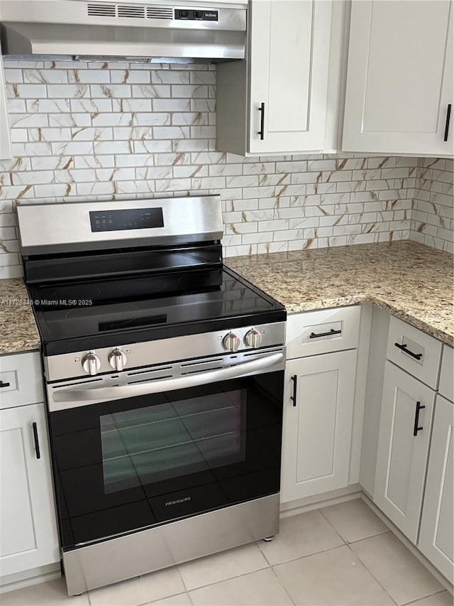 kitchen featuring light stone counters, white cabinetry, stainless steel electric stove, and light tile patterned floors