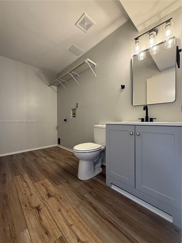 bathroom with vanity, hardwood / wood-style floors, and toilet