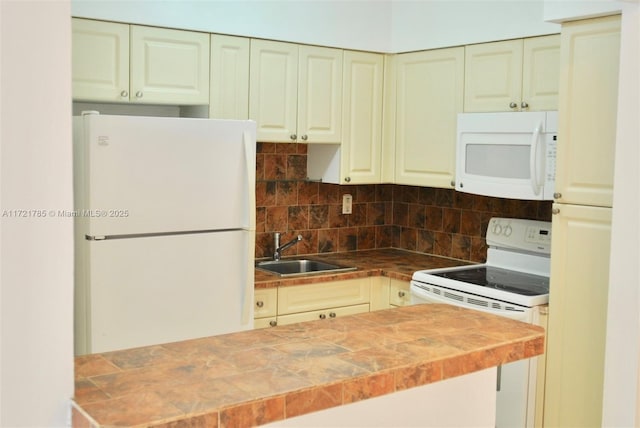 kitchen with sink, white appliances, tile counters, and tasteful backsplash