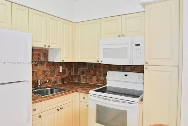 kitchen with cream cabinetry, decorative backsplash, sink, and white appliances