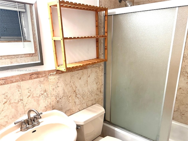 full bathroom with enclosed tub / shower combo, sink, tile walls, backsplash, and toilet