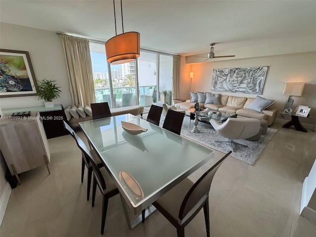 dining area featuring ceiling fan, light tile patterned flooring, and floor to ceiling windows