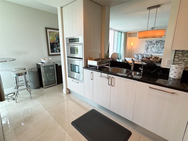 kitchen with decorative light fixtures, tasteful backsplash, sink, white cabinetry, and stainless steel double oven