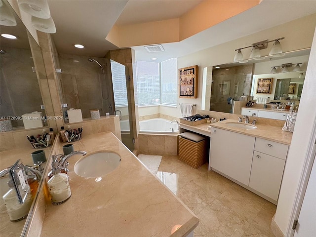 bathroom featuring vanity and independent shower and bath