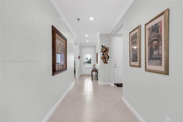 hallway featuring light tile patterned floors and ornamental molding