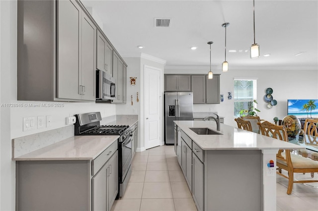 kitchen featuring decorative light fixtures, sink, gray cabinets, and stainless steel appliances