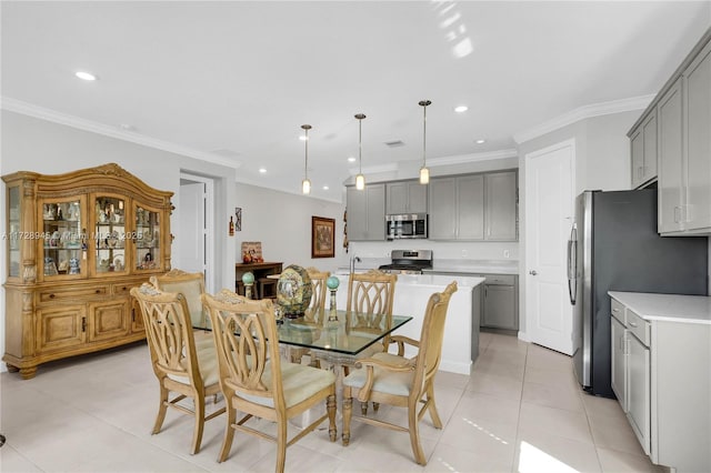 tiled dining room with ornamental molding and sink