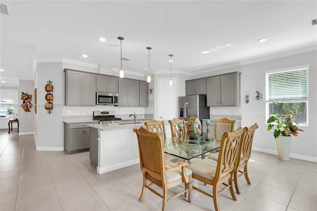 dining space with sink, light tile patterned floors, and ornamental molding