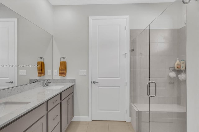 bathroom with an enclosed shower, vanity, and tile patterned flooring