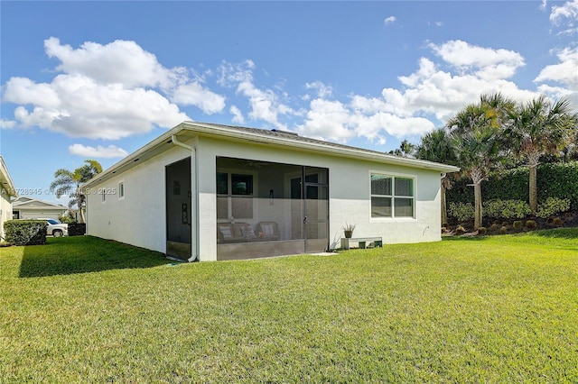 back of property with a lawn and a sunroom