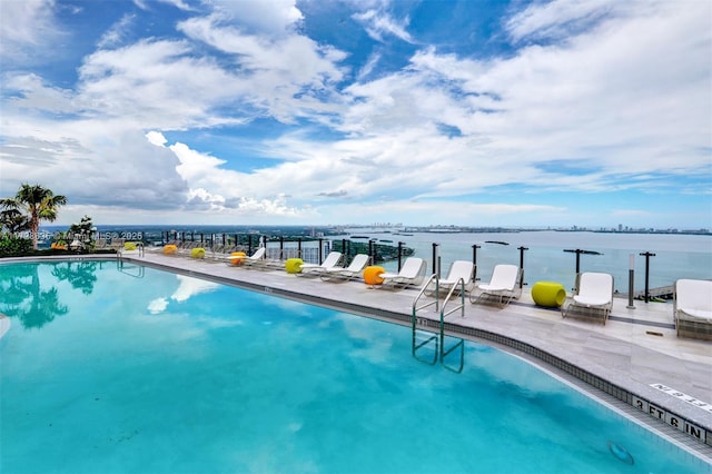 view of swimming pool with a water view and a patio