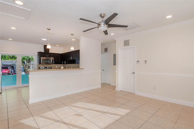 kitchen featuring light tile patterned floors, kitchen peninsula, tasteful backsplash, light stone countertops, and crown molding