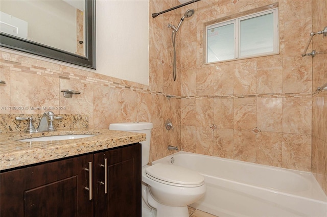 full bathroom featuring tile walls, tiled shower / bath combo, vanity, and toilet