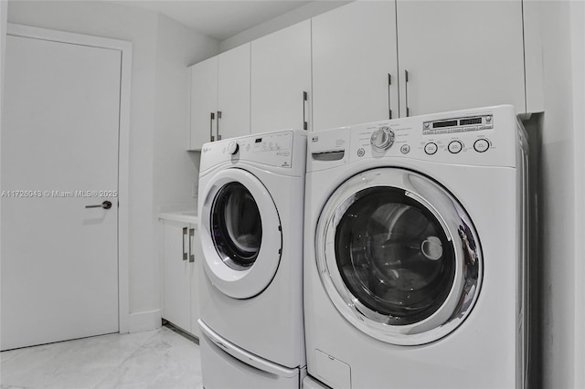 laundry area with independent washer and dryer and cabinets