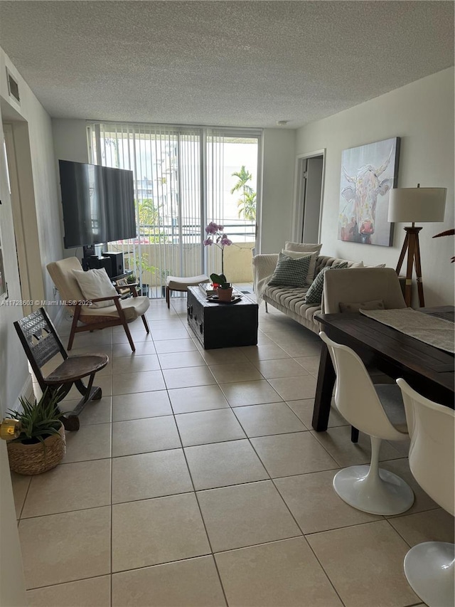 tiled living room with a textured ceiling and a wall of windows