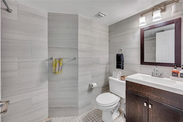 bathroom with tile patterned floors, tile walls, toilet, and vanity