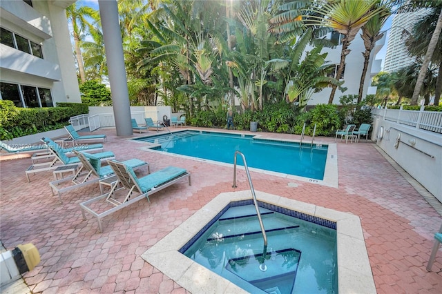 view of swimming pool featuring a hot tub and a patio area