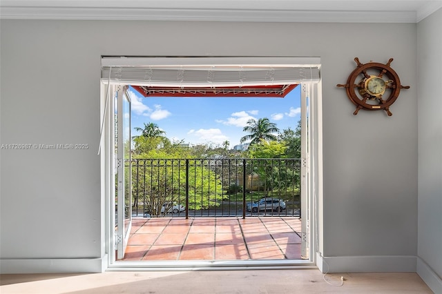 doorway featuring baseboards and ornamental molding