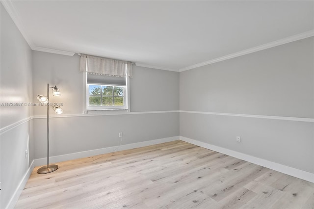 spare room featuring light wood-style flooring, ornamental molding, and baseboards