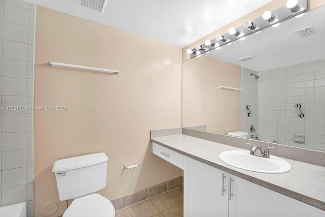 bathroom with toilet, tile patterned flooring, tiled shower, and vanity