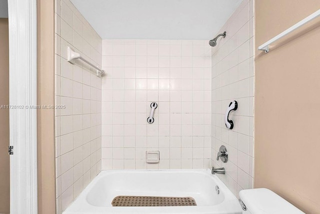 bathroom featuring toilet and tiled shower / bath combo