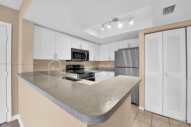 kitchen featuring appliances with stainless steel finishes, white cabinets, kitchen peninsula, and sink