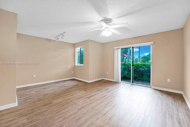 unfurnished room featuring ceiling fan, track lighting, and light hardwood / wood-style flooring