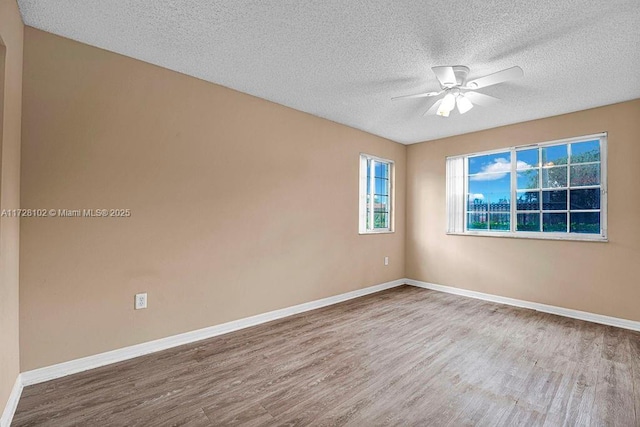 spare room featuring ceiling fan, a textured ceiling, and light hardwood / wood-style flooring