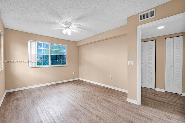 unfurnished room featuring ceiling fan, a textured ceiling, and light hardwood / wood-style floors