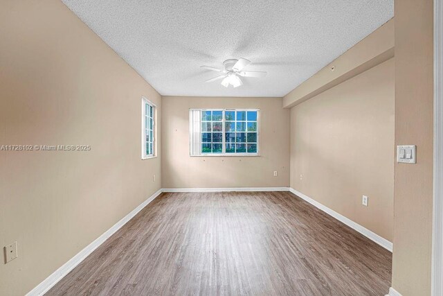 unfurnished room with ceiling fan, a textured ceiling, and hardwood / wood-style flooring