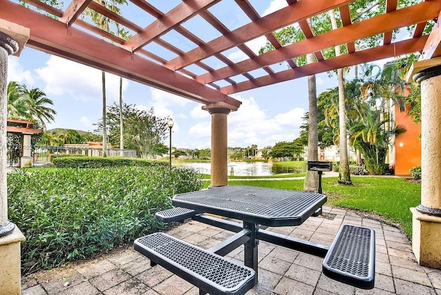 view of patio / terrace with a pergola and a water view