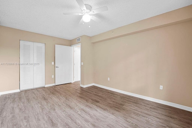 unfurnished bedroom with ceiling fan, a textured ceiling, and hardwood / wood-style flooring