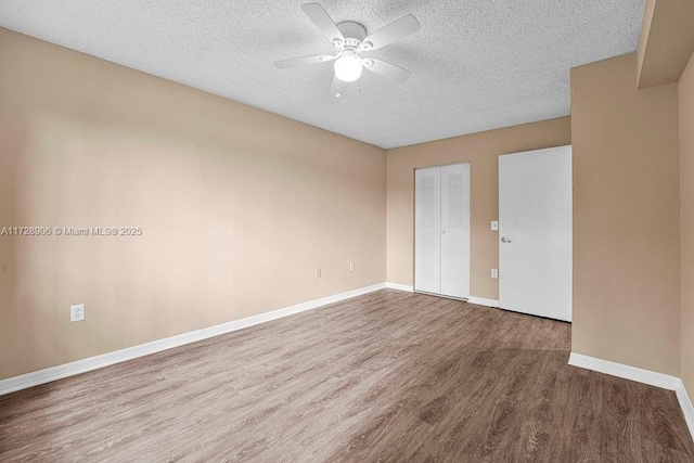 empty room featuring ceiling fan, a textured ceiling, and hardwood / wood-style flooring