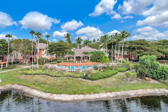 view of property's community with a lawn and a water view