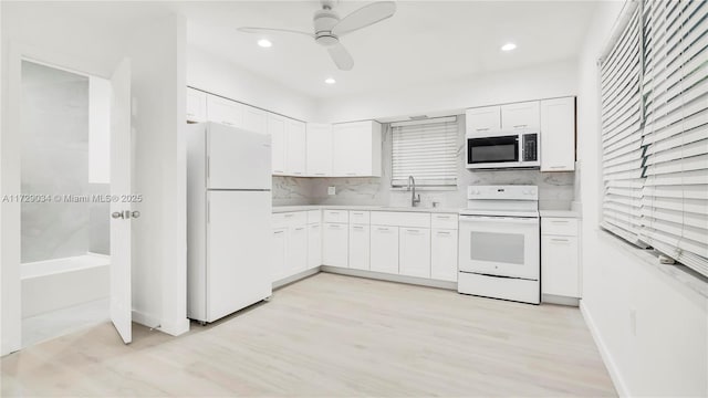 kitchen featuring ceiling fan, tasteful backsplash, white appliances, white cabinets, and sink