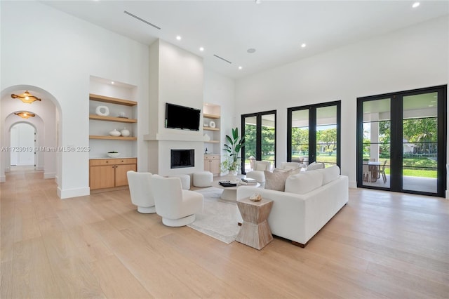 11001 SW 74th Ave, Pinecrest, FL 33156 - living room with a towering ceiling, built in features, recessed lighting, light wood-style floors, and a fireplace