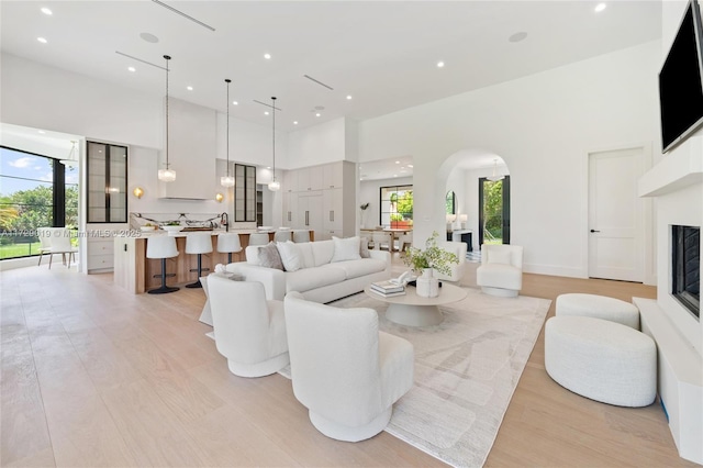 11001 SW 74th Ave, Pinecrest, FL 33156 - living area with arched walkways, plenty of natural light, light wood finished floors, a towering ceiling, and recessed lighting