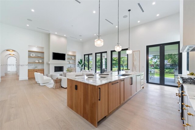 11001 SW 74th Ave, Pinecrest, FL 33156 - kitchen with a high ceiling, light wood finished floors, light stone counters, recessed lighting, and a sink