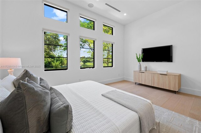 11001 SW 74th Ave, Pinecrest, FL 33156 - bedroom with baseboards, light wood-type flooring, recessed lighting, and a high ceiling