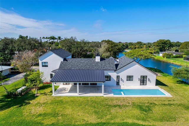 11001 SW 74th Ave, Pinecrest, FL 33156 - rear view of house with a patio, stucco siding, a yard, and a water view