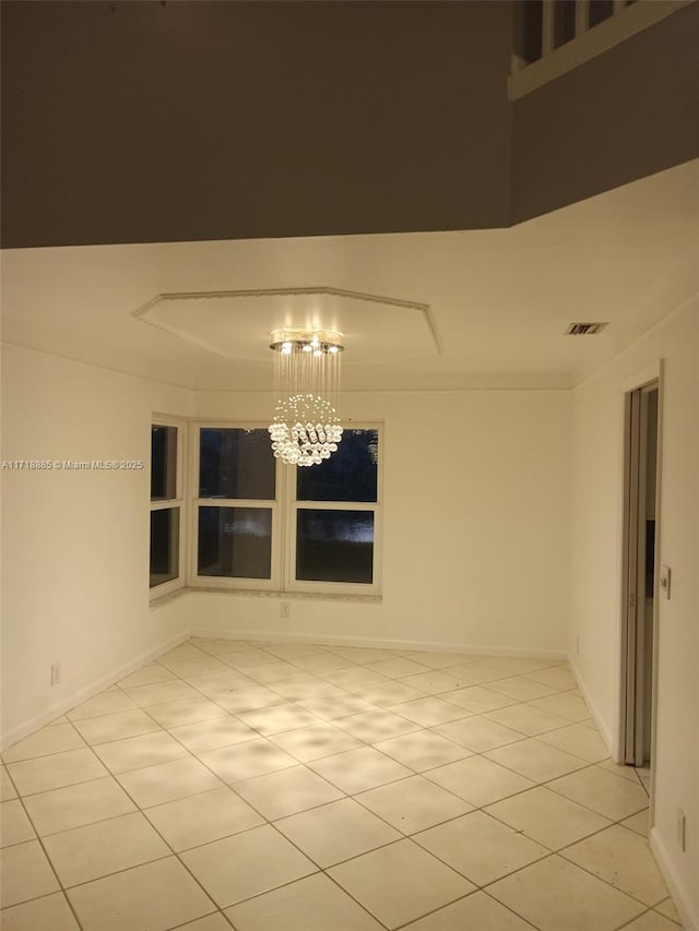 empty room featuring light tile patterned floors and a notable chandelier