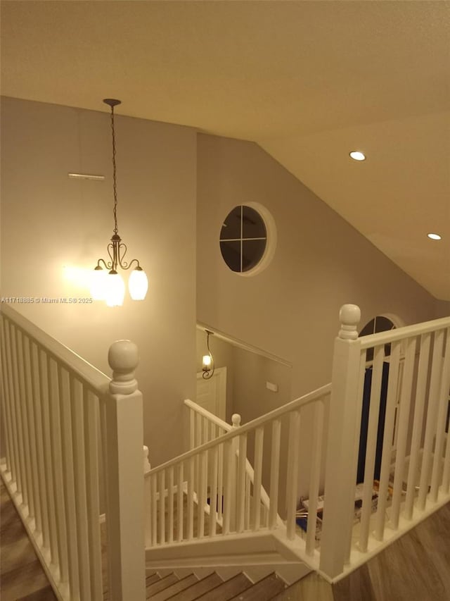 stairway featuring hardwood / wood-style flooring and vaulted ceiling