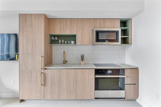 kitchen featuring light brown cabinetry, sink, light stone counters, decorative backsplash, and stainless steel appliances