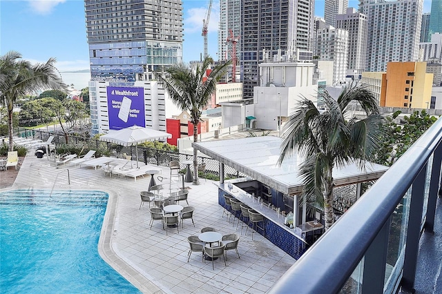 view of swimming pool featuring exterior bar and a patio