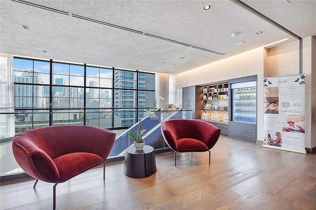 sitting room featuring expansive windows and hardwood / wood-style floors