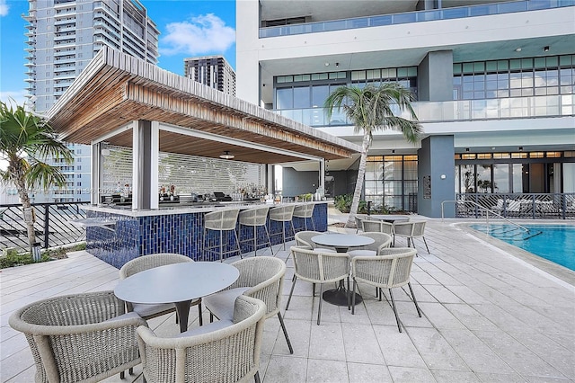 view of patio with a community pool and exterior bar