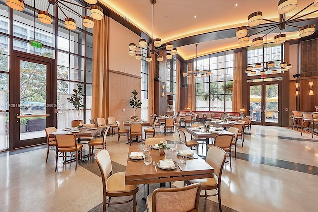 dining area with a towering ceiling and french doors