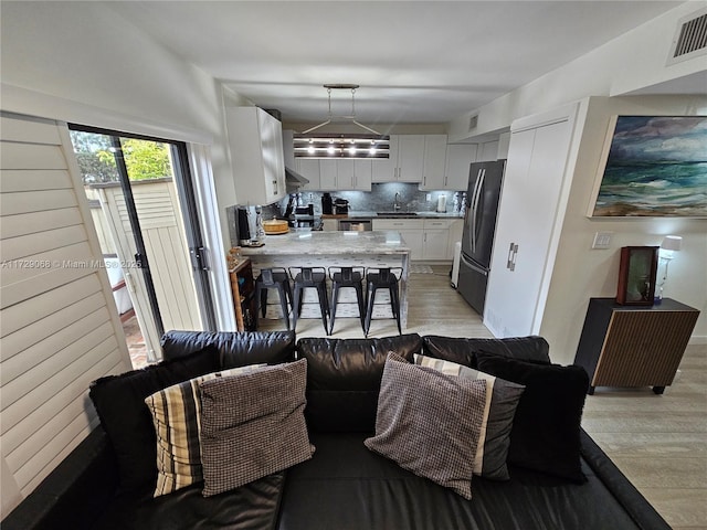 living room with sink and light hardwood / wood-style flooring